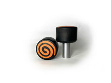 Load image into Gallery viewer, round roller skate toe stop in a black color with an orange swirl through it on a white background.