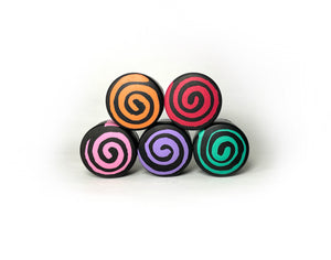 group photo of round shape toe stops. all toe stops pictured are in different colors. top left color is black with an orange swirl through it. right top is black with a red swirl through it. bottom left color is black with a pink swirl through it. bottom middle is a black color with a purple swirl through it. bottom right is a black color with a teal swirl through it.