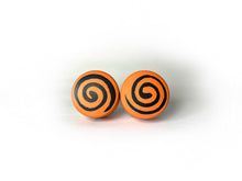 Load image into Gallery viewer, orange color round roller skate toe stop with a black swirl through it on a white background. 