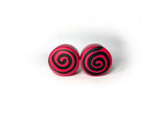Load image into Gallery viewer, red color round roller skate toe stop with a black swirl through it on a white background. 
