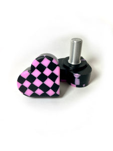 pink and black checker patterned heart shaped roller skate toe stop on a white background